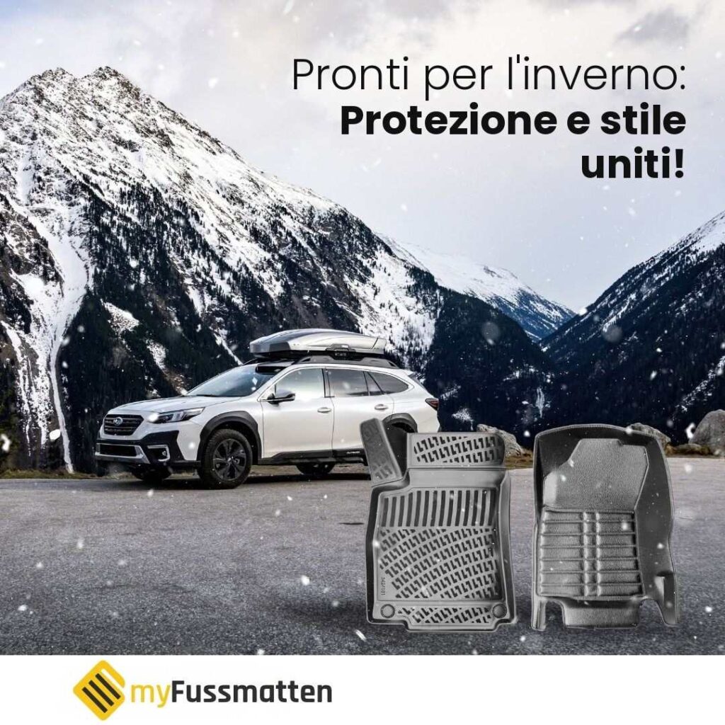 SUV bianco con box da tetto tra le montagne innevate accanto a due tappetini auto neri